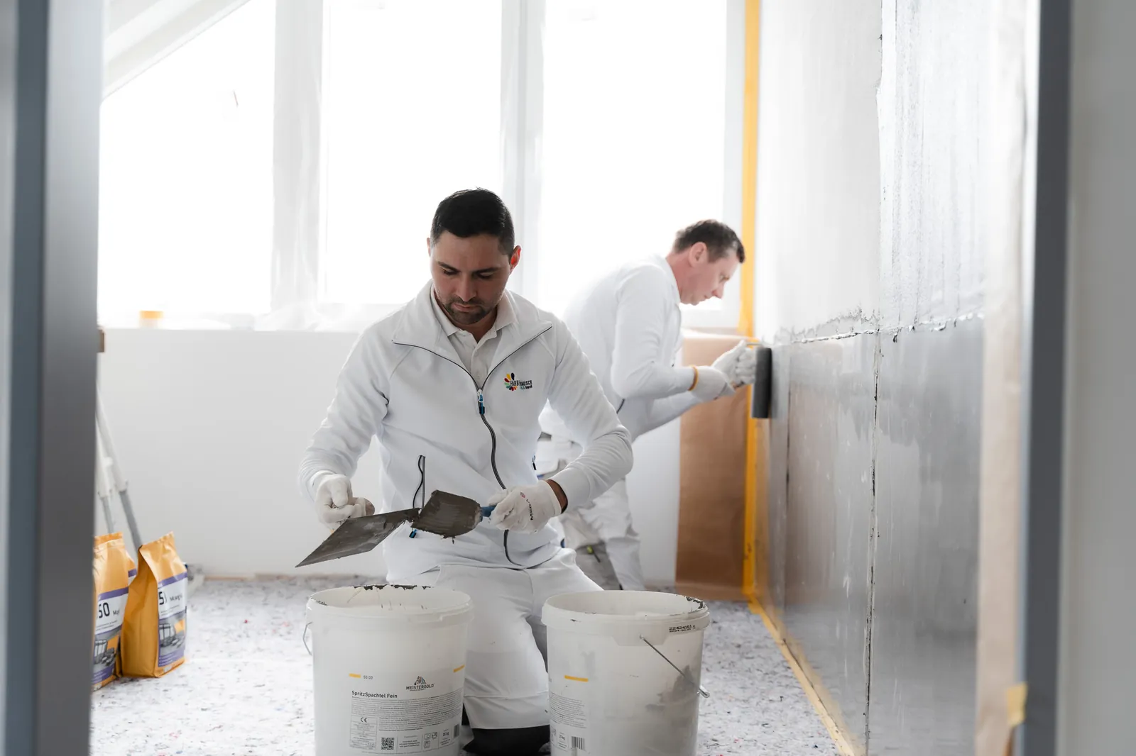 Spachtelmasse wird angerührt und an die Wand gebracht