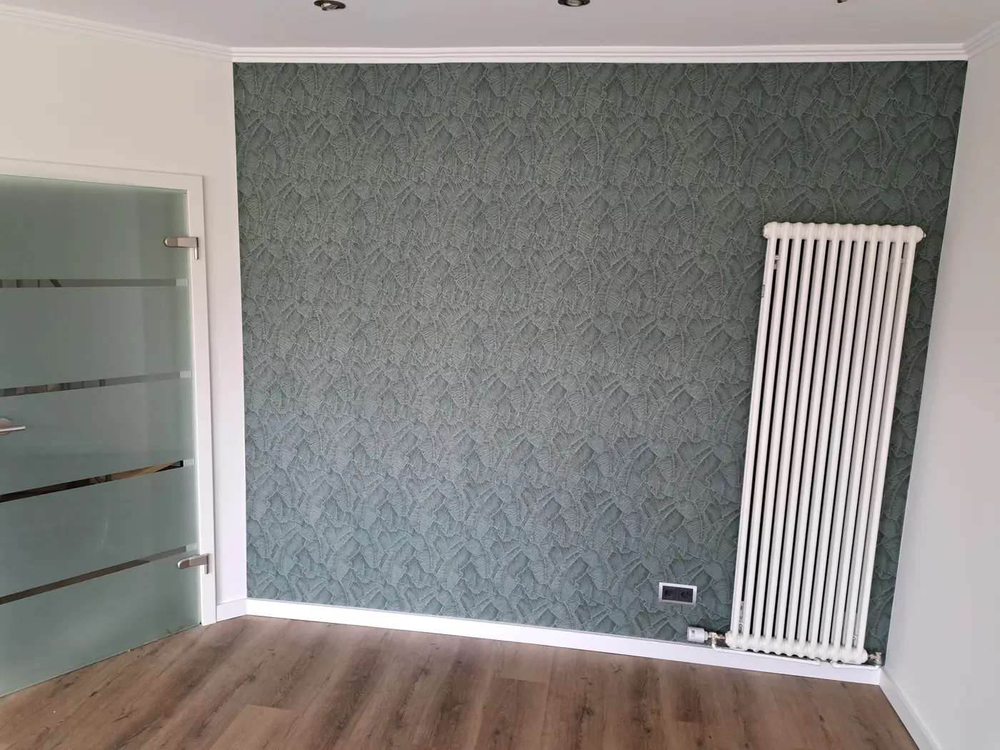 Akzentwand in Grün: Blättermuster mit Relief, Kanten exakt an Decke und Sockel